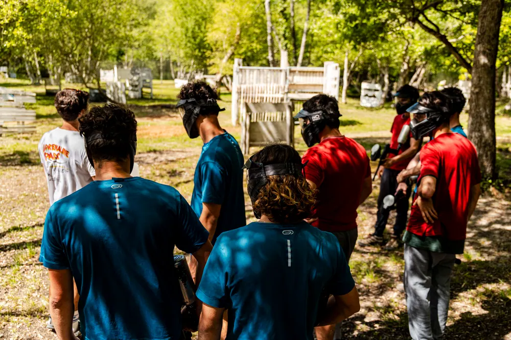 Équipe de joueurs paintball masqués en action sur le terrain
