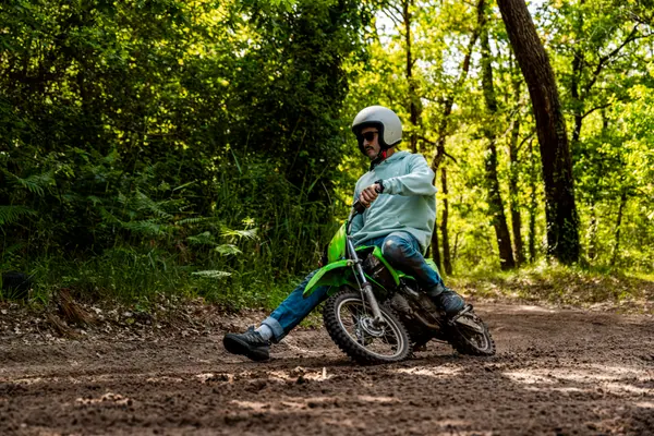 Pilote sur mini-moto verte au repos