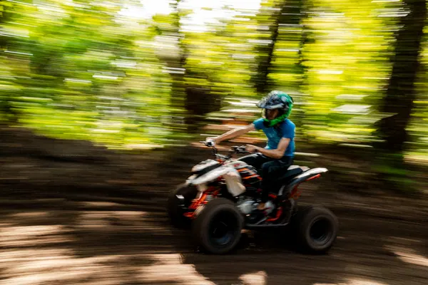 Quad enfant en action dans la pinède